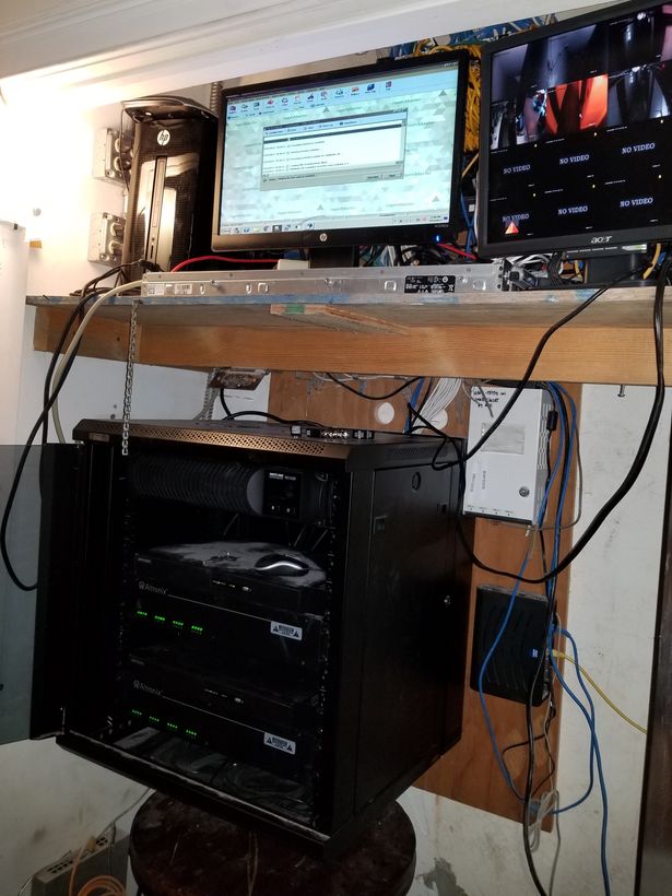 The same wall two days later with a wall-mount cabinet, switches racked and cable dressed to the sides