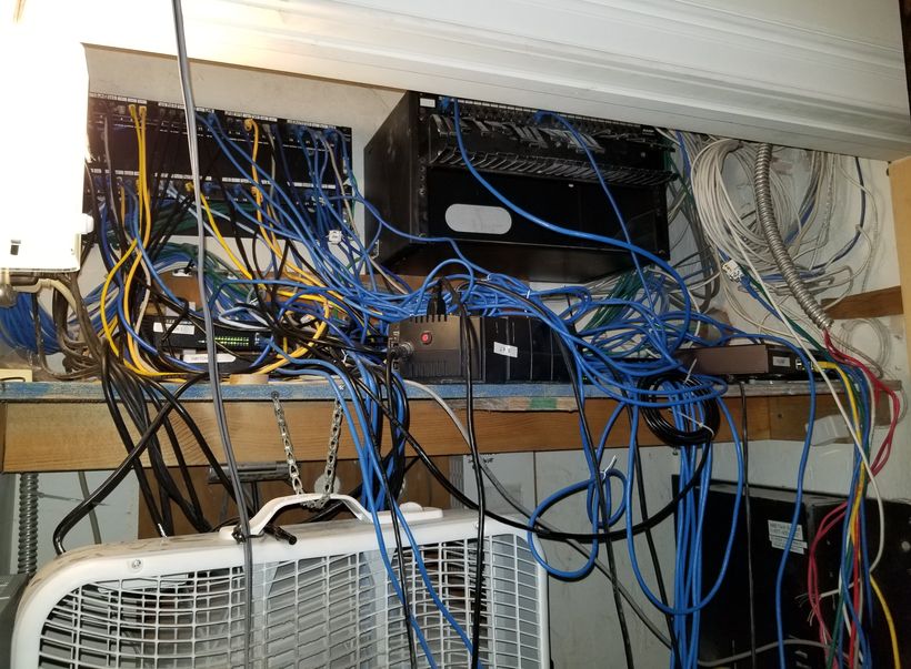 A shelf of undressed network cable running in every direction above an air handler