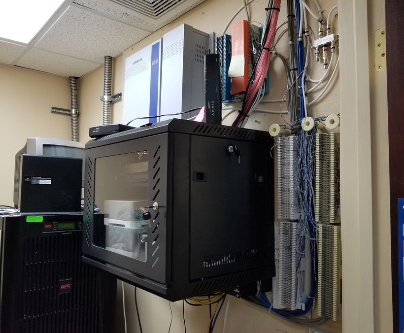 The same room hours later with a wall cabinet mounted and terminated beside punch-down blocks