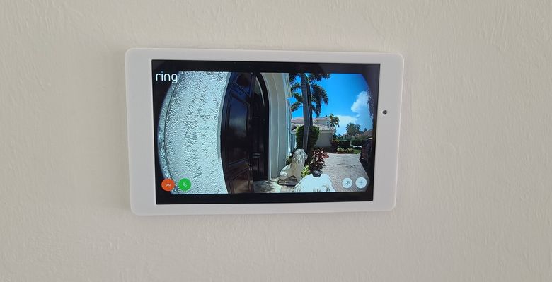 A flush wall-mounted control tablet showing a live door camera view